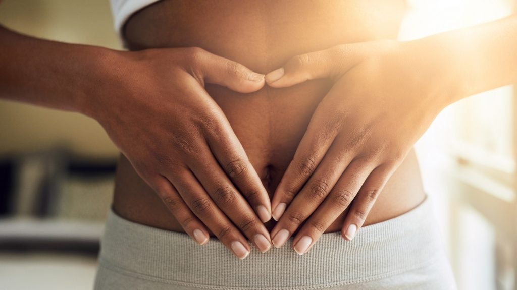 Hands of woman on stomach